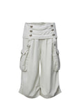 Victory jorts in beige from the Double Punch SS26 'Illusory Victory' collection. Flipped waistband design. Napoleon military jacket inspired double-breasted decorative buttons. Large side pockets. Baggy cargo shorts silhouette. Soft, comfortable 100% cotton fabric.